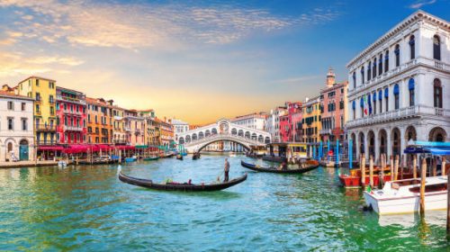 Venice Grand Canal, view of the Rialto Bridge and gondoliers, Italy.